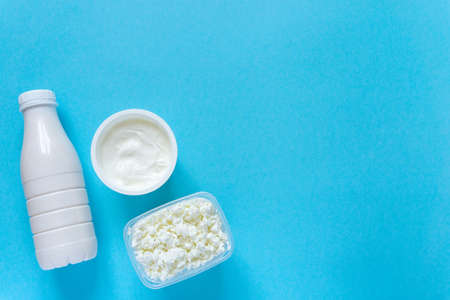 Set of fresh dairy products. Milk, cottage cheese and sour cream on blue background, copyspaceの写真素材