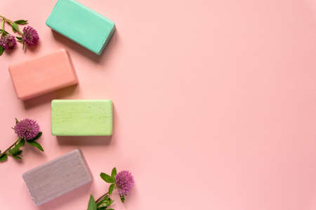 Flat lay of various natural soap bars with clover flowers on pink background. Space for textの写真素材