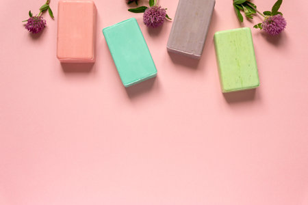 Flat lay of various natural soap bars with clover flowers on pink background. Space for textの写真素材