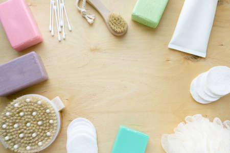 Frame of bath and hygiene products. Soap, shampoo and massage brushes on wooden background, copyspaceの写真素材