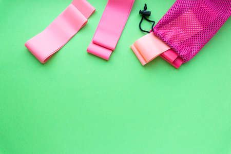 Flat lay of elastic bands for fitness on green background, copyspaceの写真素材