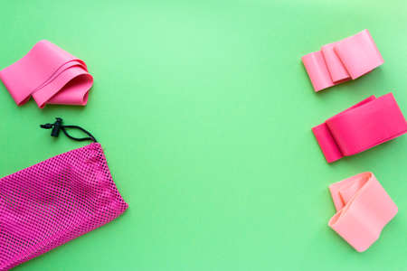 Flat lay of elastic bands for fitness on green background, top viewの写真素材