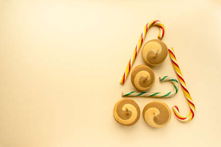 Edible christmas tree made of cookies and lollipops cane on beige background, space for textの写真素材