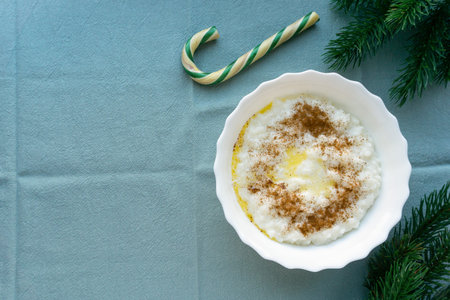 Christmas rice porridge with butter and cinnamon on blue textile background, space for textの写真素材