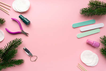 Christmas flat lay of manicure accessories with fir branches on pink background, top view.の写真素材