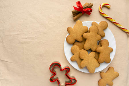 Homemade christmas gingerbread cookies in the shape of man on beige textile background, copyspaceの写真素材