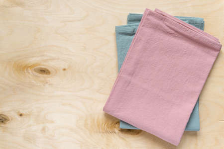 Pink and blue linen kitchen towels on wooden background, space for textの写真素材