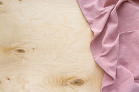 Pink linen kitchen towel on wooden background, space for textの写真素材