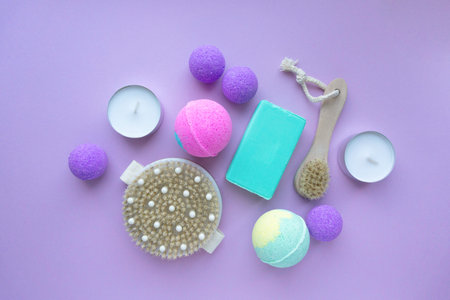 Spa flat lay. Bath bombs, soap and massage brushes on purple background, top viewの写真素材