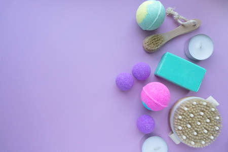 Spa flat lay. Bath bombs, soap and massage brushes on purple background, space for textの写真素材