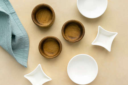 Wooden and ceramic small bowls on beige background, top viewの写真素材