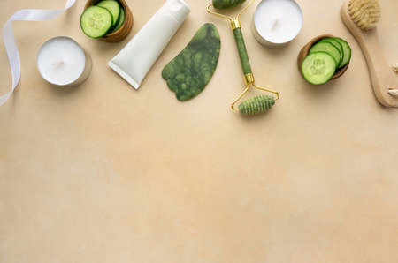 Jade roller and gua sha scraper for facial massage on beige background, copyspaceの写真素材