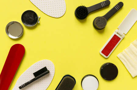 Frame of shoe care products. Cream and brushes on yellow backgroundの写真素材