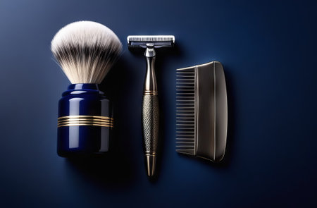 Male grooming kit. Razor, shaving brush and comb on dark blue background, top viewの素材