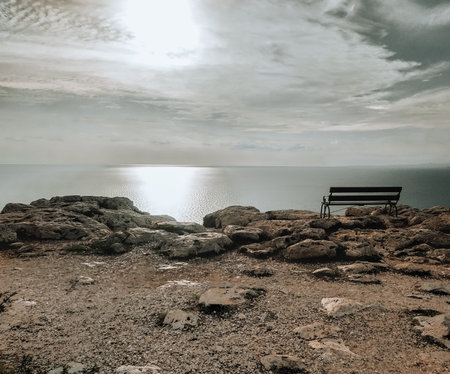Summer sunny landscape. Cavo Greco, Cyprus, Mediterranean Sea coast. An empty bench on a cliff.