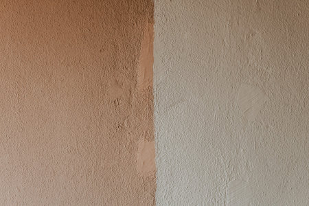 A concrete wall painted in white and pink colors. A plaster wall texture background.