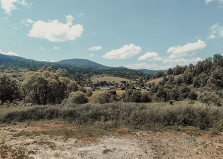 Green hills and village houses, summer mountain landscape. Clear horizon over the mountain range.