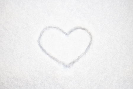 The heart is drawn on fresh snow. The concept of love and romance. Valentines Day. Winter background