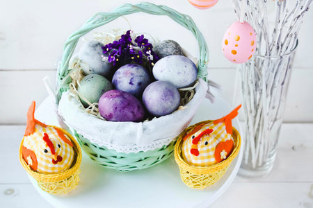 Easter eggs in a wicker basket on a white background. Decorative chicken with eggs. easter tree....