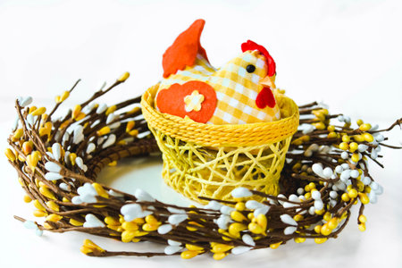 Decorative chicken in a yellow wicker basket on a white isolated background with space for text. Easter card Provence. Easter composition.の写真素材