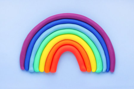 Colorful rainbow of plasticine on blue background. Made from plasticine. Isolate.の写真素材