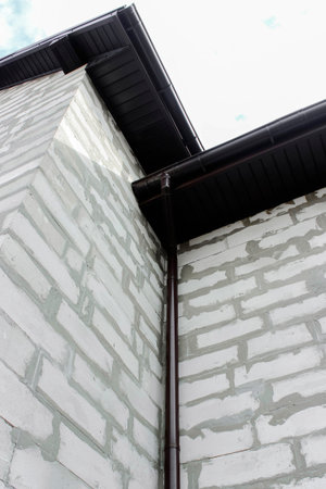 Sewer pipe on the facade of a newly constructed building made of gas blocks. A building without a...