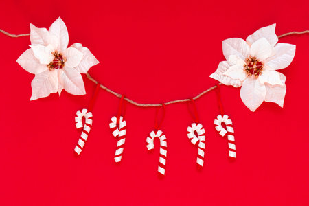 Toy candies made of felt isolated on the red background with copy space. The atmosphere of Christmas and New Year. Christmas banner, mock up.の写真素材