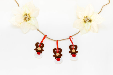 Toy Deers hanging on a rope isolated on the white background with copy space. The atmosphere of Christmas and New Year. Christmas banner, mock-up.の写真素材