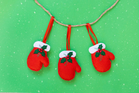 Red gloves hanging on a rope isolated on the green background with copy space. The atmosphere of...