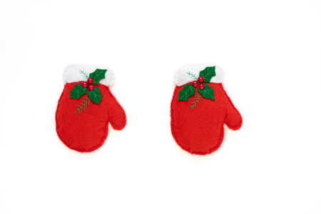 Red gloves hanging on a rope isolated on the white background with copy space. The atmosphere of Christmas and New Year. Christmas banner, mock up.の写真素材