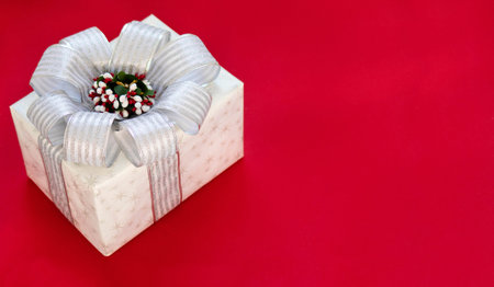 Gift box is isolated on a red background with copy space. The atmosphere of Christmas and New Year....