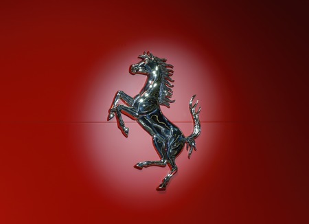 FRANKFURT - SEP 2017: Ferrari horse logo in metallic on red background in a light spot at IAA Frankfurt Motor Showのeditorial素材