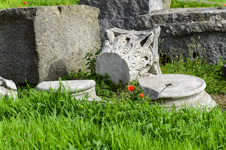 Pompeii ruins: remains of ancient columns on grass with poppies at archaeological site. Pompeii town was destroyed by eruption of volcano Vesuvius, Italyの写真素材