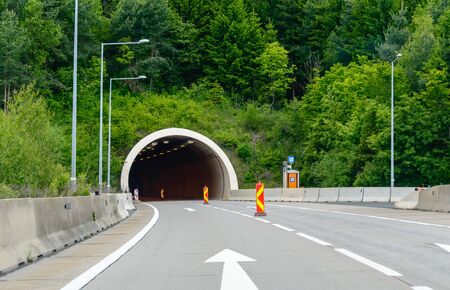 Highway road tunnel in the mountain with traffic dividers to mark a construction site. Motorway in Austrian Alps.の写真素材