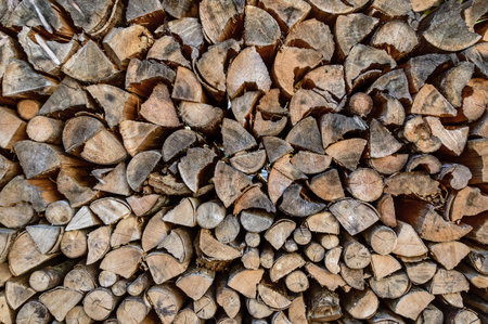 Stack of sawn tree logs detail. Stacked pile of wood logs stored for winter as firewood. Lumber...