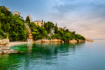 Glavanovo beach in Rijeka, Croatia at sunset. Stunning croatian coast with small beach, buildings,...