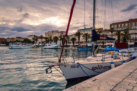 Split, Croatia - May 21, 2019: Split old town with colorful buildings, Riva Promenade, palm trees and boats at sea. Vivid waterfront evening view at sunset. Popular touristic destinationのeditorial素材