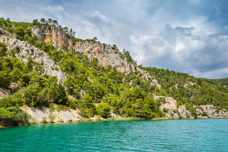 Green hills with forest around Krka river in beautiful Krka National Park, Croatia. Touristic boats...