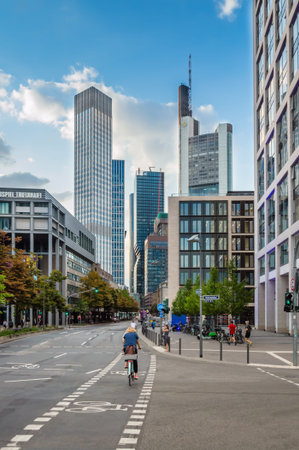 Frankfurt am Main, Germany - Aug 2019: Skyscrapers in the financial district of Frankfurt on clear sunny day. Bicyclist driving on bicycle lane in large cityのeditorial素材