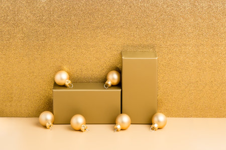 Golden podium for product presentation on beige and luxury glitter background, gold Christmas balls. New year festive holiday design or mock up for package placement, promotion sale, cosmetic displayの写真素材