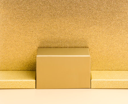 Abstract golden background with podium for product presentation on beige and luxury glitter gold background. Festive holiday design or mock up for package placement, promotion sale or cosmetic displayの写真素材
