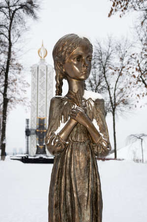 Kyiv, Ukraine - JAN 2019: Close-up of child holding spikelet monument in front of National Museum of Holodomor Genocide also known as Memorial in Commemoration of famine victims of 1923-1933 yearsのeditorial素材