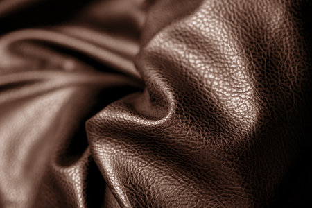 Brown leather with waves and folds. Textured background of faux or eco leather, vegan artificial material on PVC base. Close up of texture, macroの写真素材