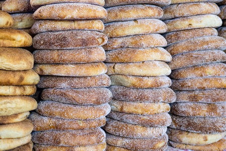 Stack of fresh Moroccan bread at street market stall. Traditional freshly baked bread called khubz, batbout, Mkhamer or harcha in Morocco.の写真素材