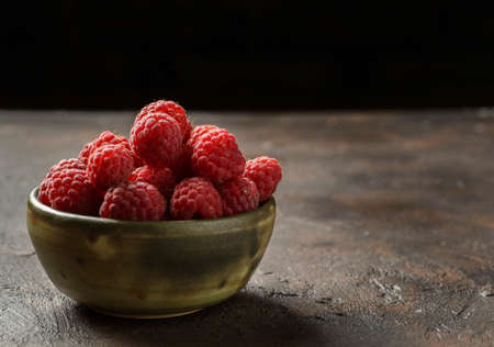 raspberries in bowl in a low keyの写真素材