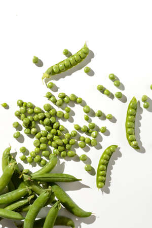 green peas and pods on a white backgroundの写真素材