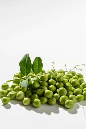 green peas and pods on a white backgroundの写真素材