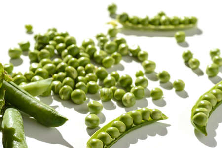 green peas and pods on a white backgroundの写真素材