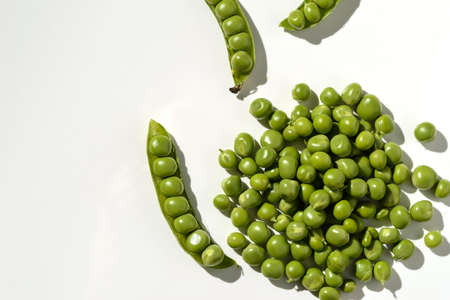 green peas and pods on a white backgroundの写真素材