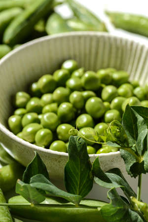green peas and pods on a white backgroundの写真素材
